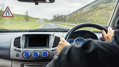 View from a car's interior as a man drives on a rural road in Perthshire, Scotland