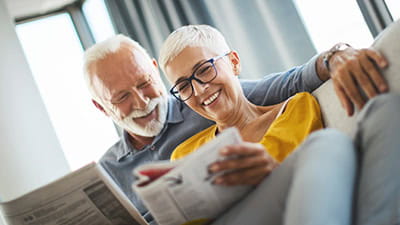A couple reading the Saga Equity Release guide on the sofa