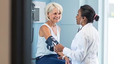 A mature woman having her blood pressure taken