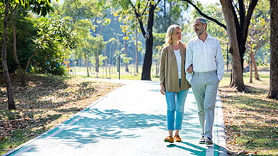 Senior couple taking a walk in a park during a summer morning.