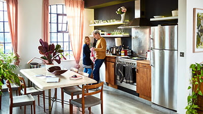 A mature couple washing up at home in their flat