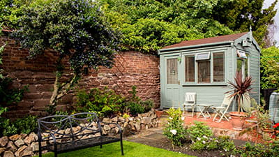 A fancy shed in a pretty residential garden