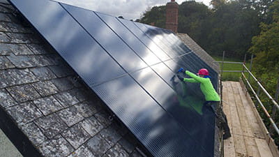 Man attaching solar panels to roof