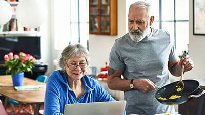 A couple at home looking at their laptop