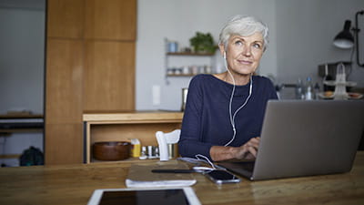 Senior woman working on laptop while sitting at home