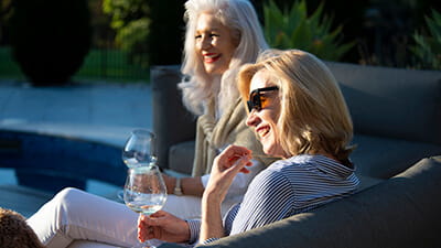 Two ladies enjoying the evening sunshine sat in their holiday home garden