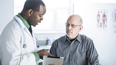 A senior man having a consultation with a doctor in a white coat.