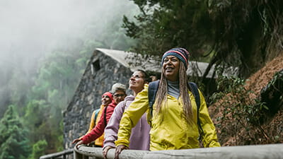 Group of women with different ages and ethnicities having fun walking in foggy forest