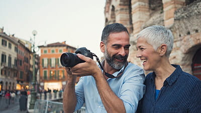 Mature couple taking photos as tourists in the city of Verona