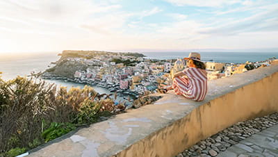 A holidaymaker watching the sunset over a beautiful Greek seaside town