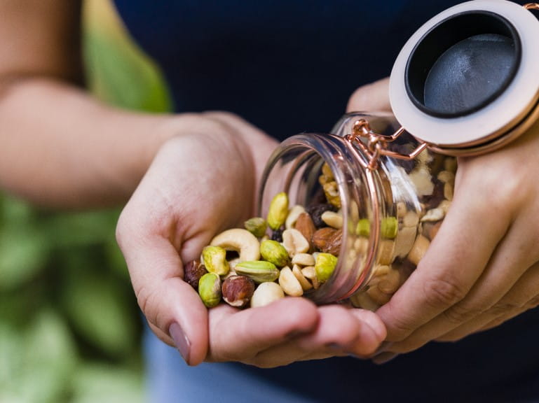 A close up of nuts being poured out of a kilner jar | Getty/Julio Ricco