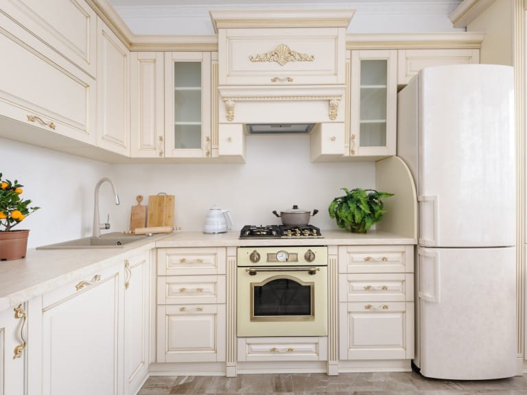A kitchen with cream cabinets and matching fridge