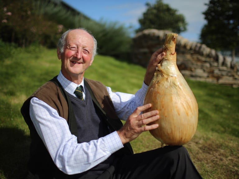 Peter Glazebrook with his onion weighing 18lbs 1oz | Getty