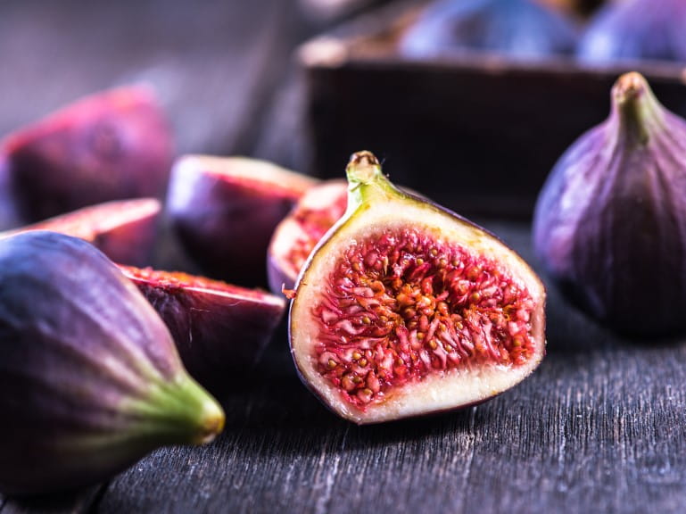 Several juicy figs, one cut open | Getty/merc67