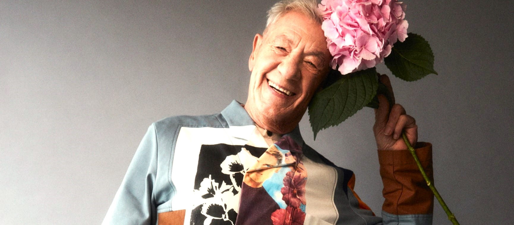 Sir Ian McKellen playfully posing with hydrangeas | Alex Bramall/Kintzing