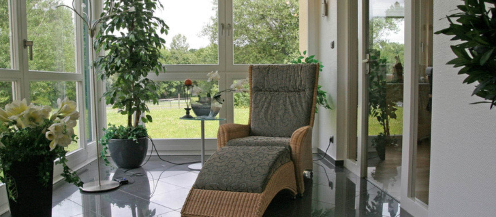 A small conservatory with a green reclining chair and plant