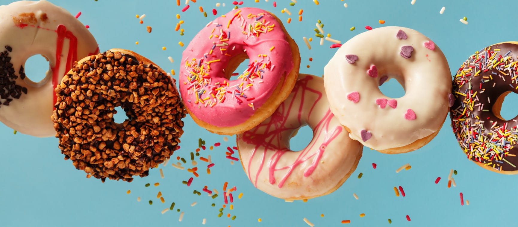 Colourful iced doughnuts with sprinkles | Shutterstock