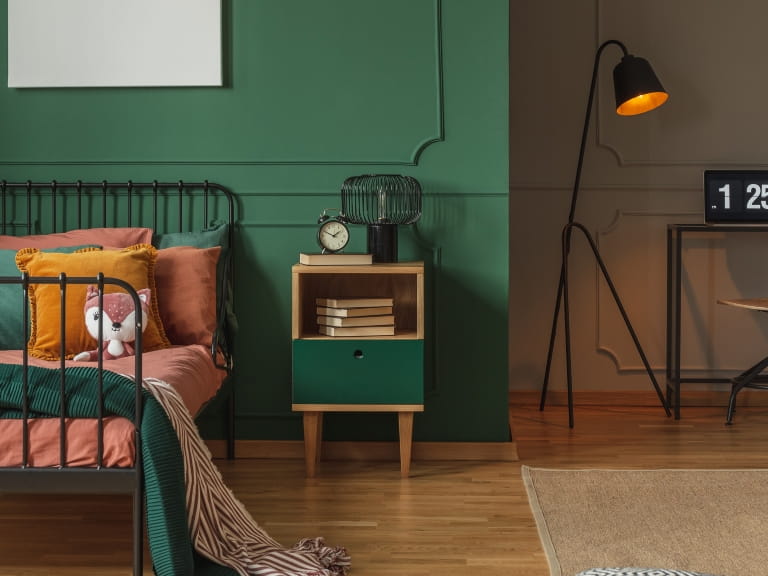 A bedroom decorated in green shades with a matching bedside table