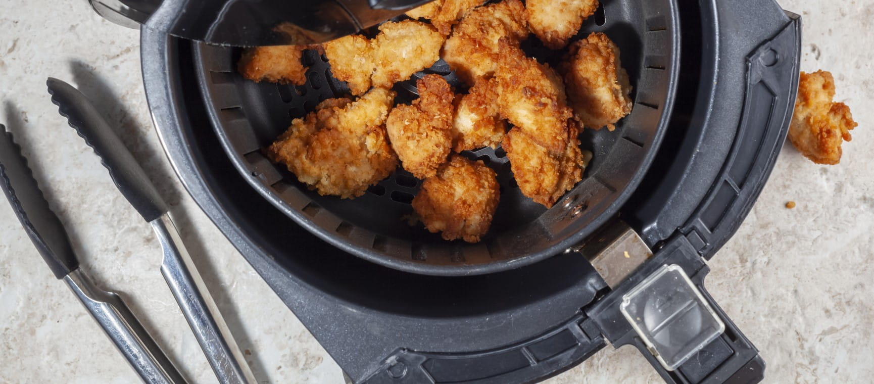 Air frying homemade chicken nuggets | Getty/Grandbrothers