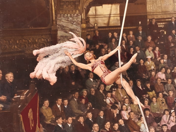 An old photograph of an aerial performer with a feathered headdress 'flying' in front of an audience at Blackpool Tower Ballroom