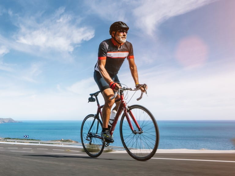 A man riding a road bike on a sunny day