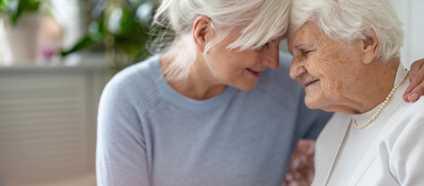 Happy senior woman with her adult daughter at home, representing people living longer | Getty/PIKSEL
