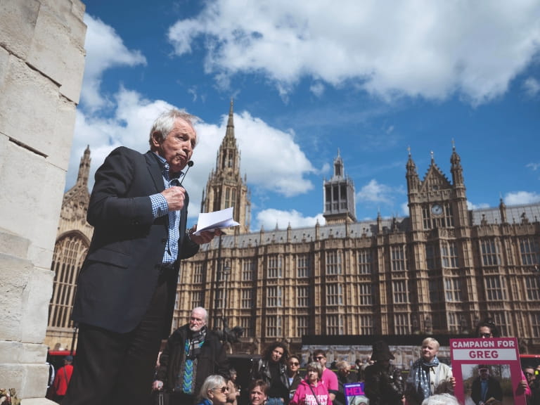 A man addresses a crowd outside UK parliament in London