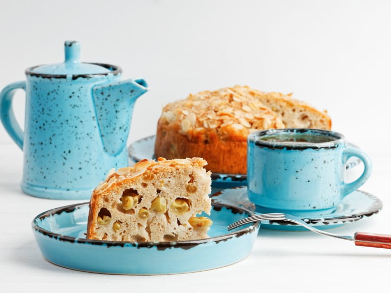 Homemade grape cake and cup of tea on white wooden table | Getty/Mark_KA