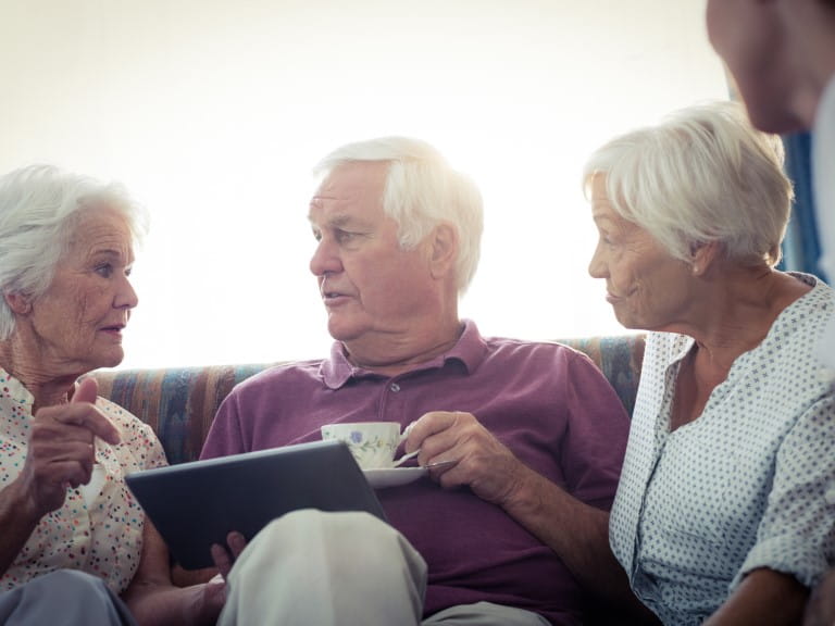 Seniors using a tablet computer in the retirement house