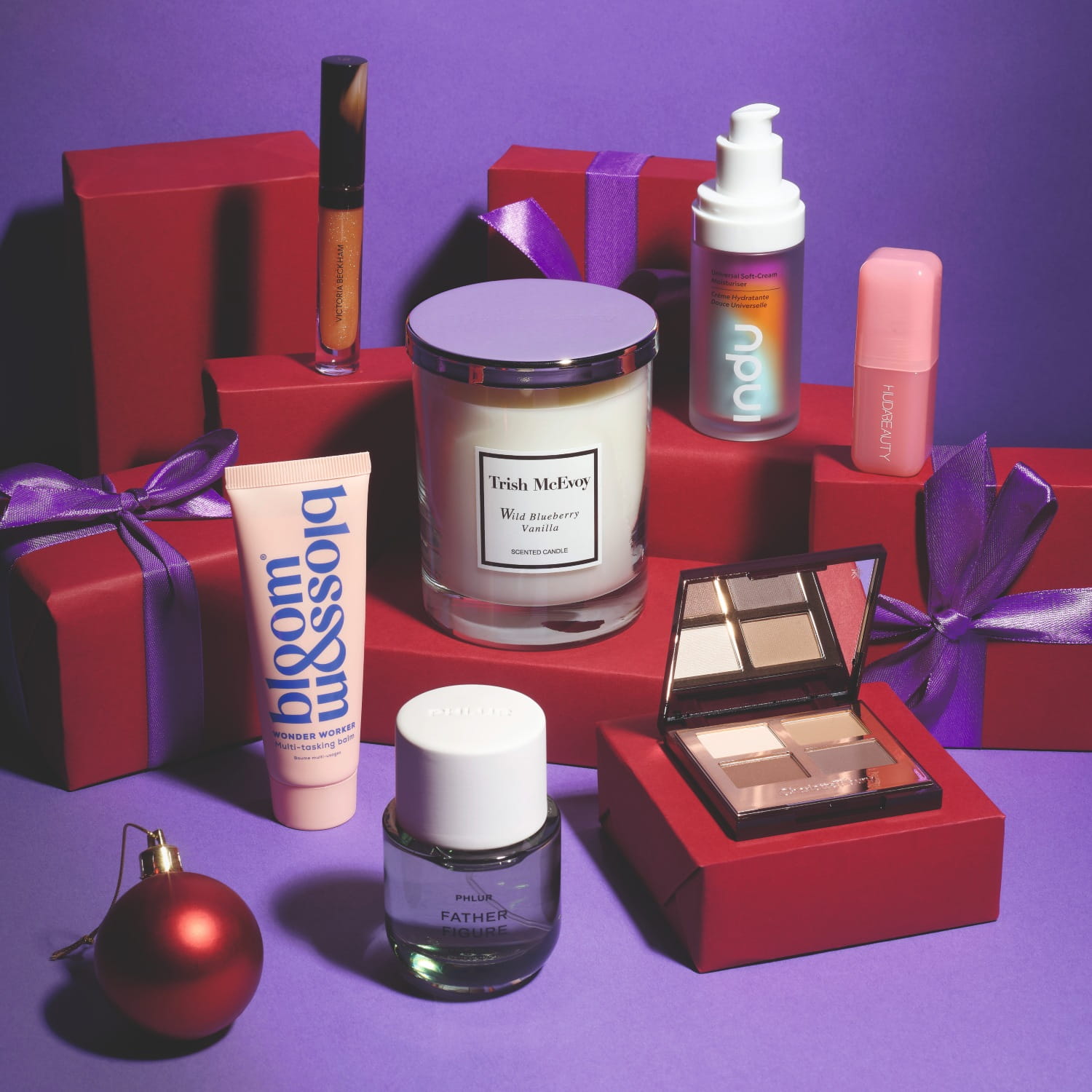 Beauty products that make great gifts including a candle, balm, perfume, eyeshadow palette, moisturiser, blusher and shampoo bar.