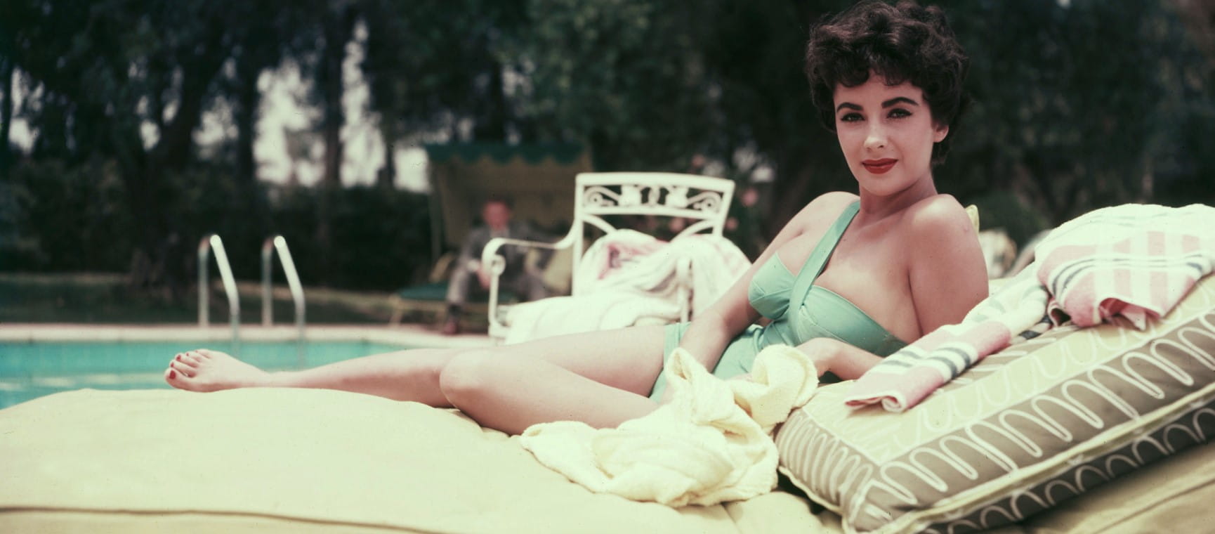 Elizabeth Taylor reclining on a sun lounger 