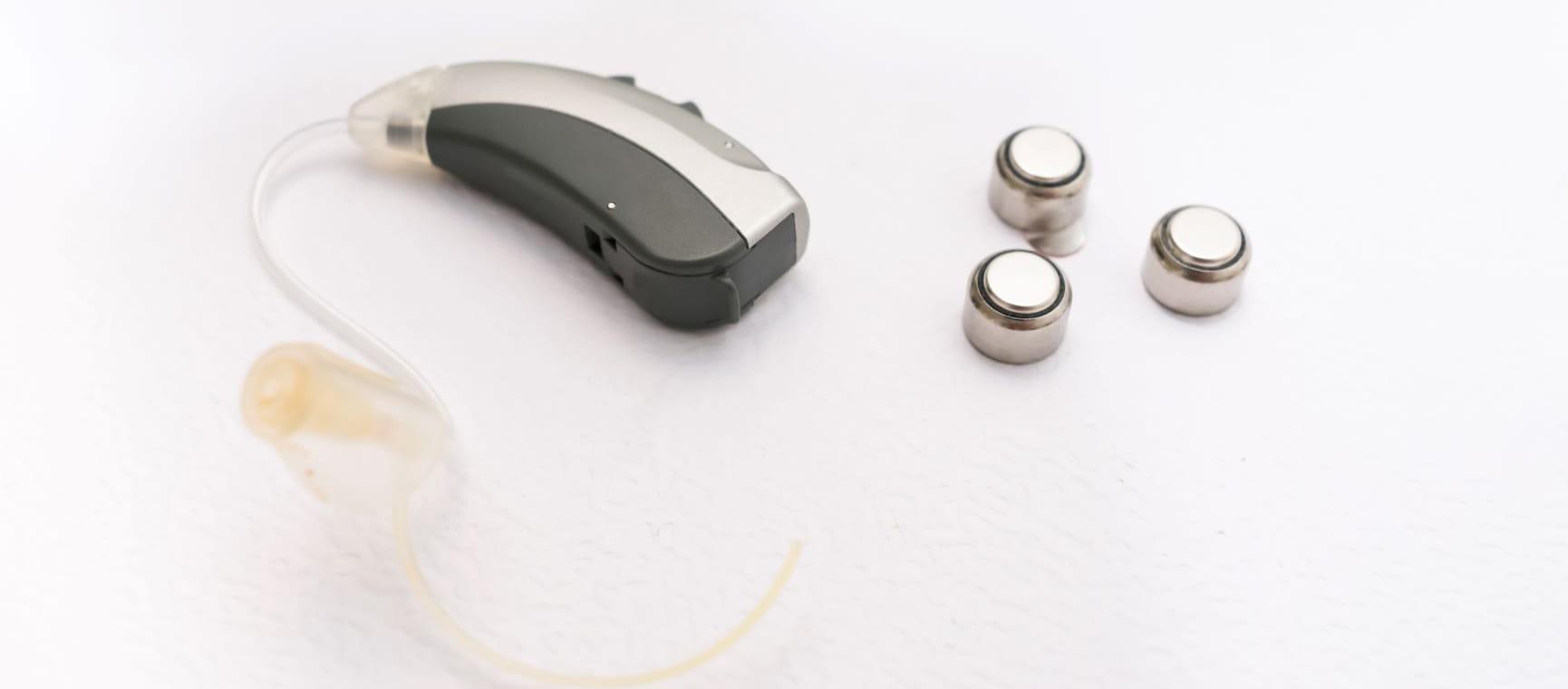 Hearing aid with three batteries next to it
