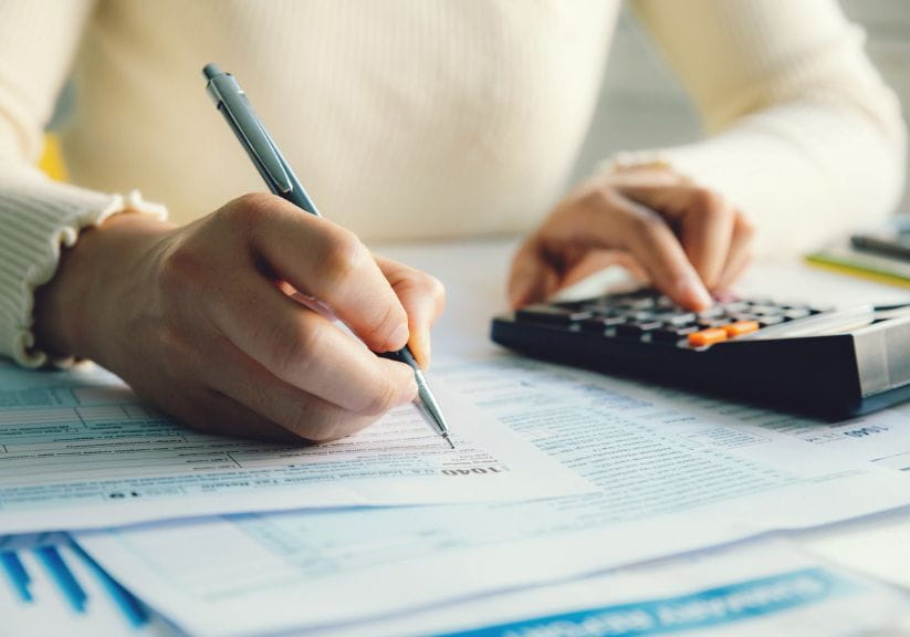 A woman filling in an income tax return with a calculator