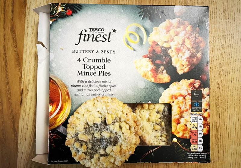 A box of Tesco crumble mince pies on a wooden table