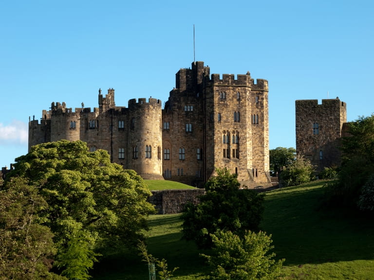 Alnwick Castle, Northumberland, on top of a hill on a sunny day