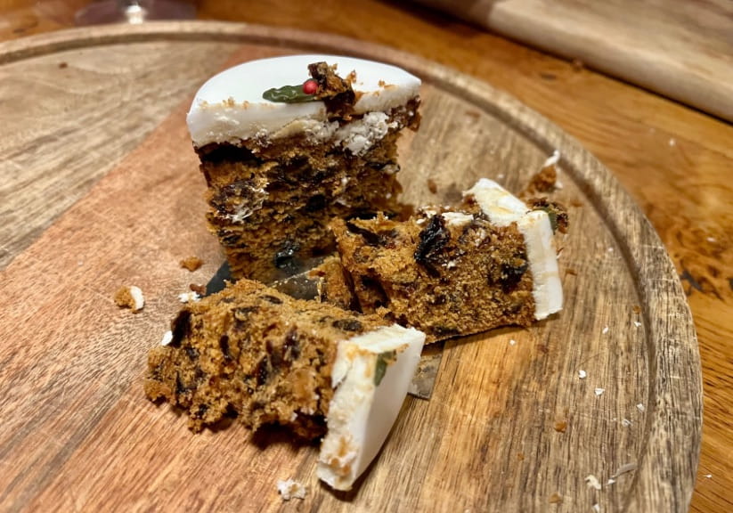 A Lidl mini Christmas cake cut open on a wood board