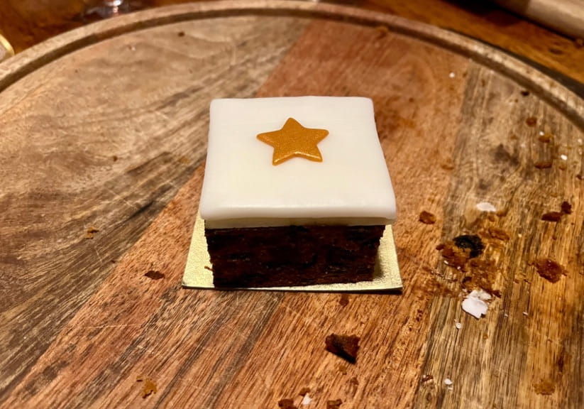 A morrisons mini Christmas cake on a wooden board