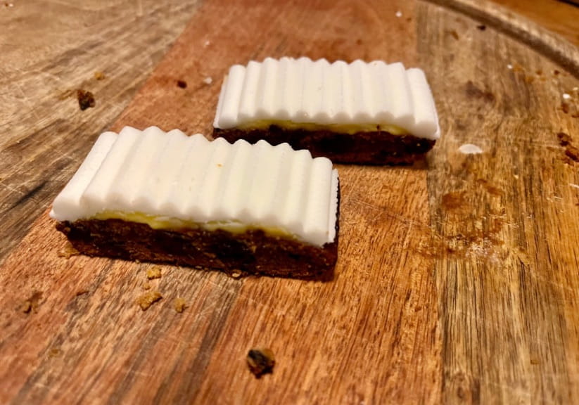 Two Mr Kipling Christmas slices on a wood board