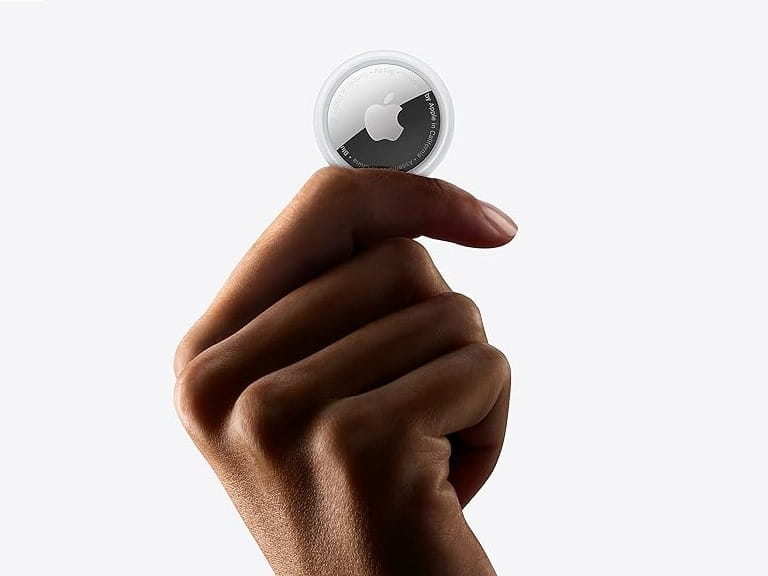 A hand holding an Apple Air Tag