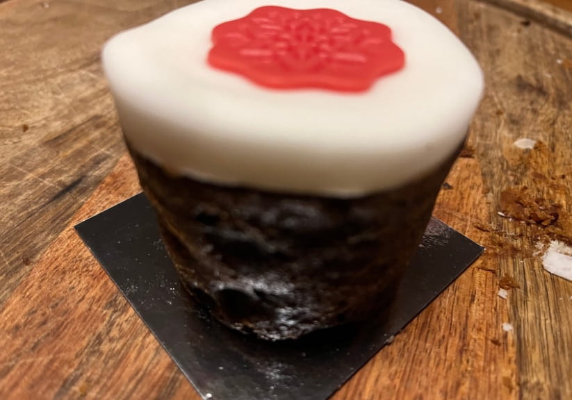 A Waitrose mini Christmas cake on a wood board