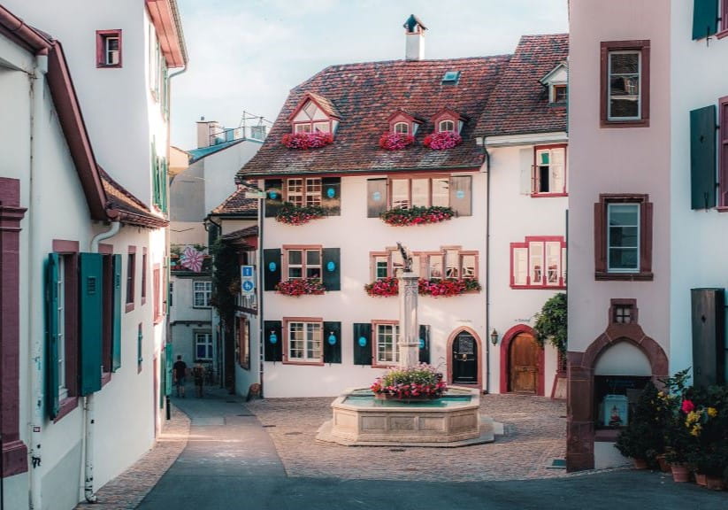 Houses in Basel's Old Town bathed in a pink light with colourful hues of flowers in the windowboxes