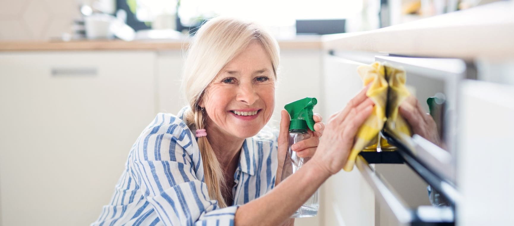 Woman cleaning the oven gleefully