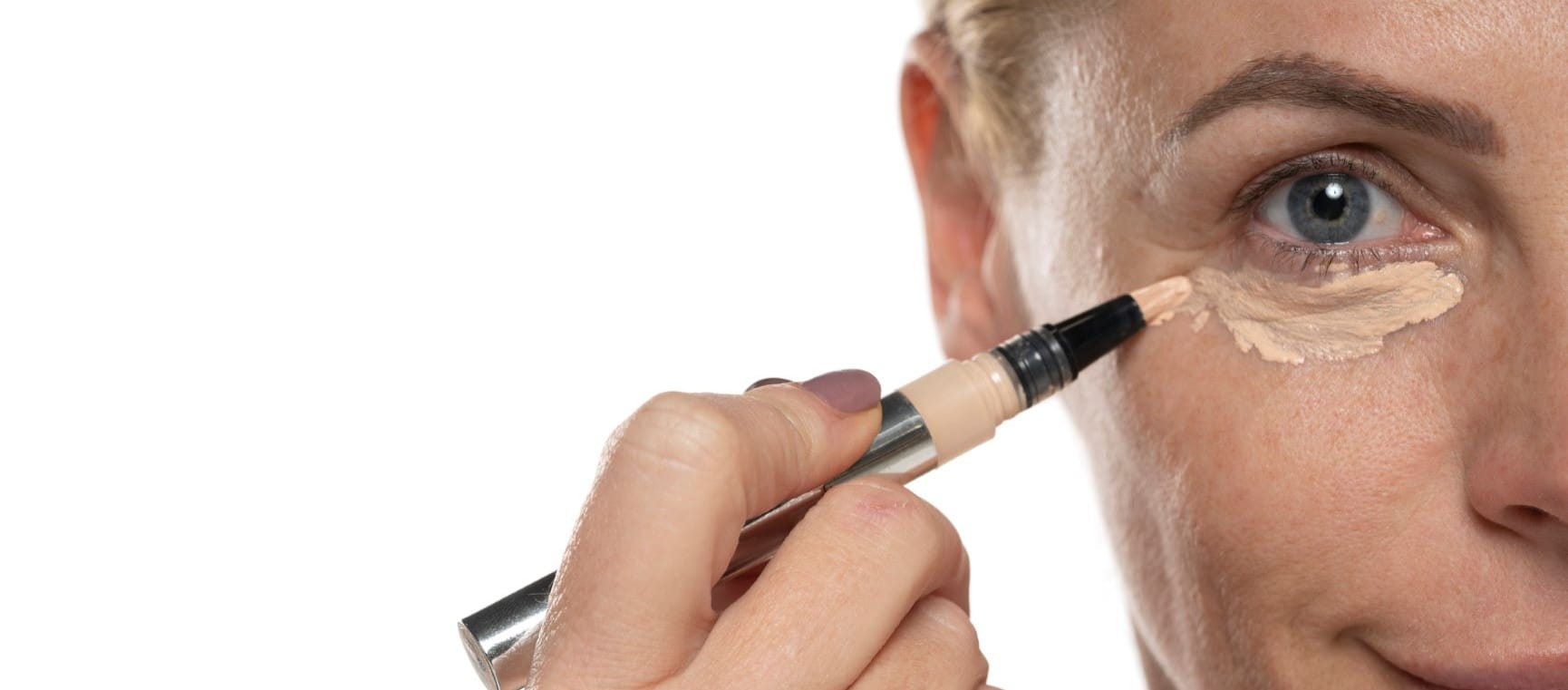 woman putting concealer on