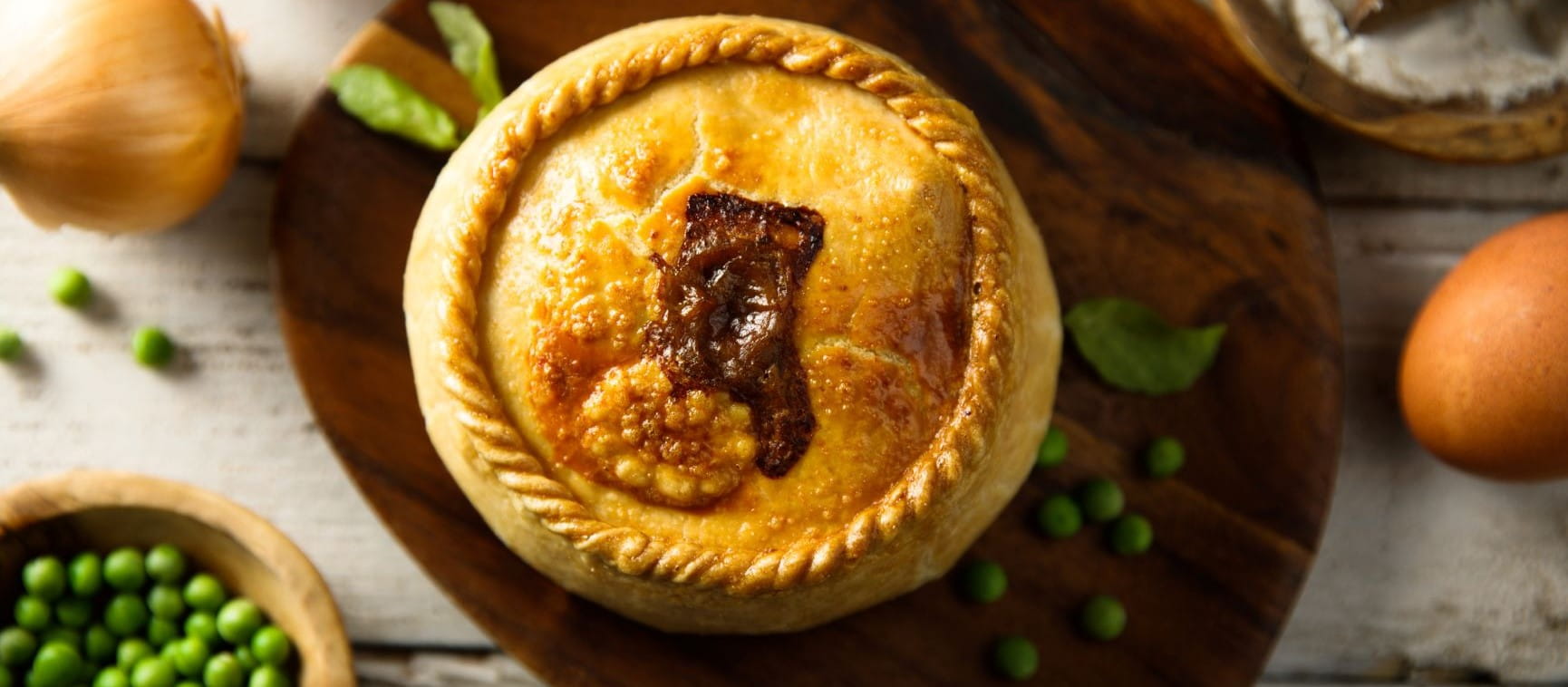 Steak and ale pie with some peas and onion