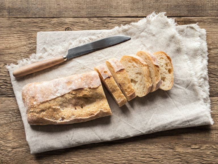 A ciabatta loaf on a table sliced up