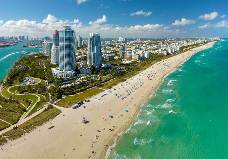 A view of Miami beach with the sea on one side and skyscrapers along the coast