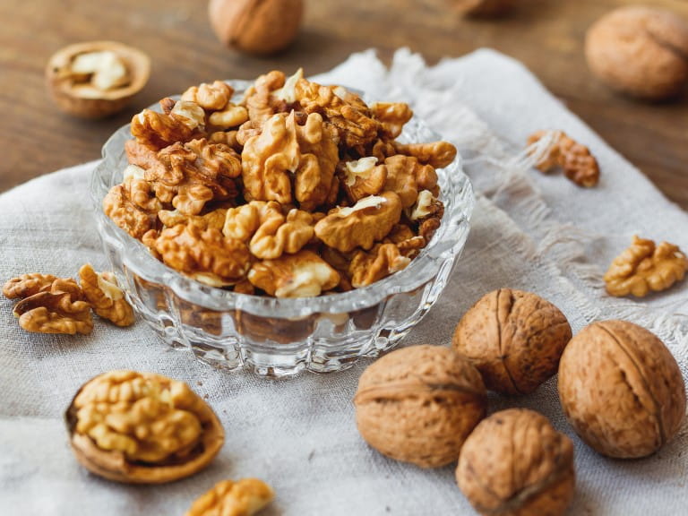 Glass bowl with walnuts on rustic homespun napkin