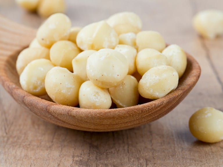 Macadamia nuts in a wooden spoon | Getty/Diana Taliun