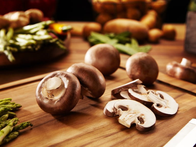 Mushrooms on cutting board during preparation | Getty/Oliver_Jungmann