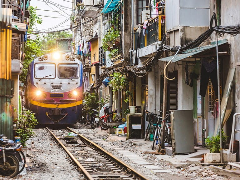 The Reunification Express passing houses in Hanoi